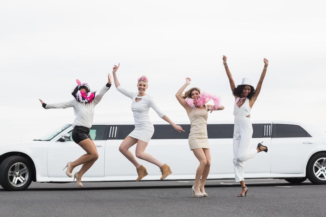 four ladies jumping beside the car