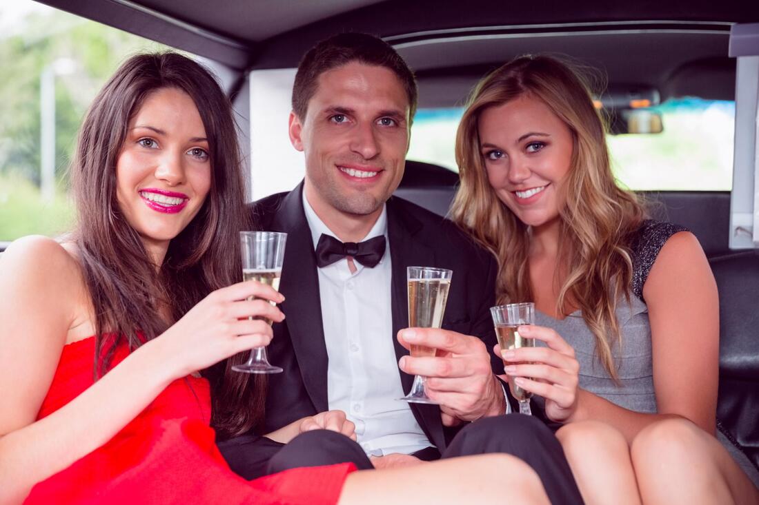 people inside the car holding wine